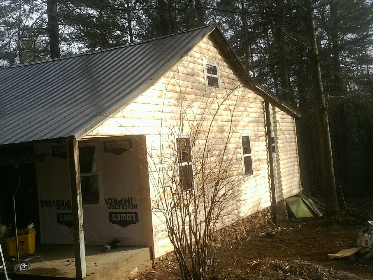 Log siding gable end under a dark metal roof edge in Fontana