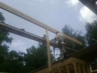 Carpenter setting a ridge beam over a new addition frame — Ice Dam Removal by Roofing Brothers in Fontana
