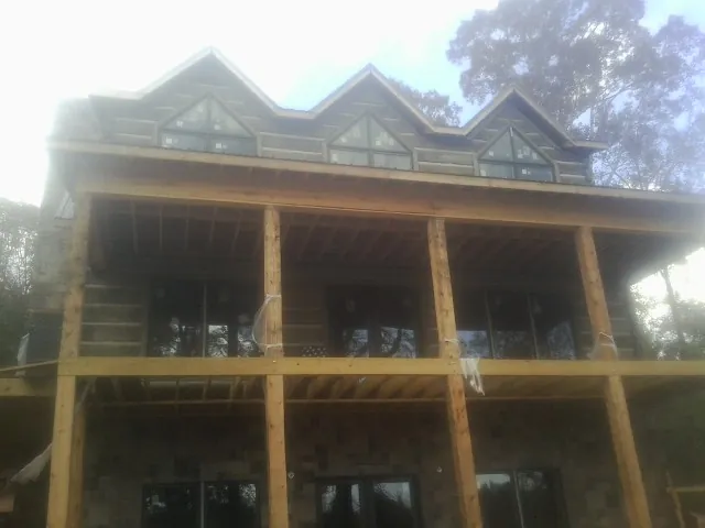 Dormers and porch framing on a large log home under construction — Roof Coating work by our crew in Fontana