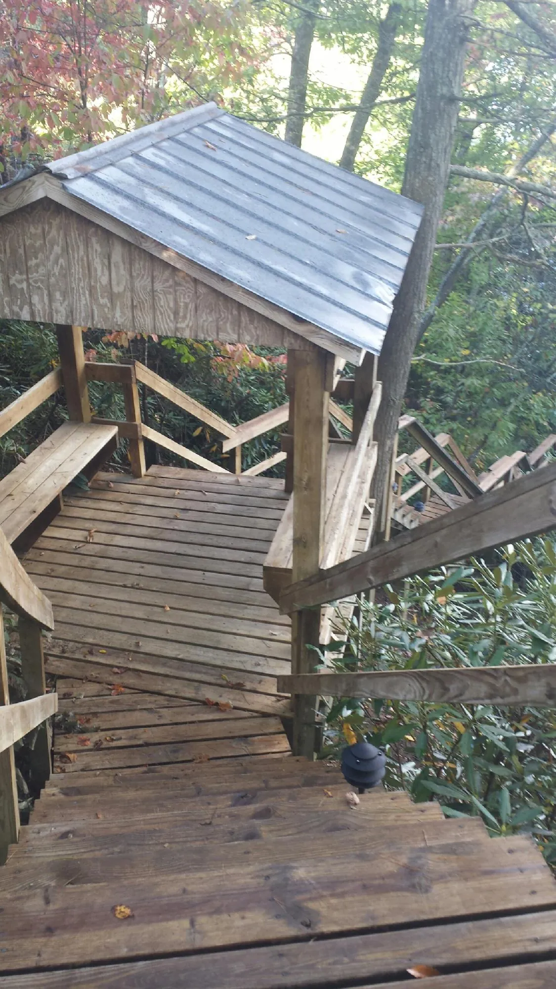Metal roofed shelter over wooden steps on a wooded walkway — Skylight Repair & Installation work by our crew in Fontana